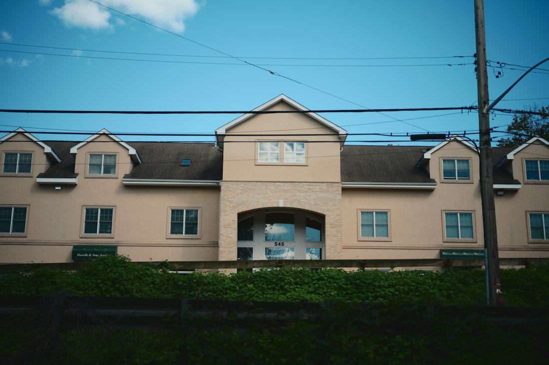 A large beige building with dormers under a blue sky