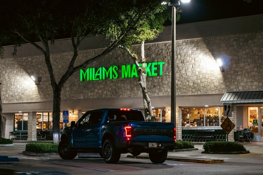A truck parks outside a market at night