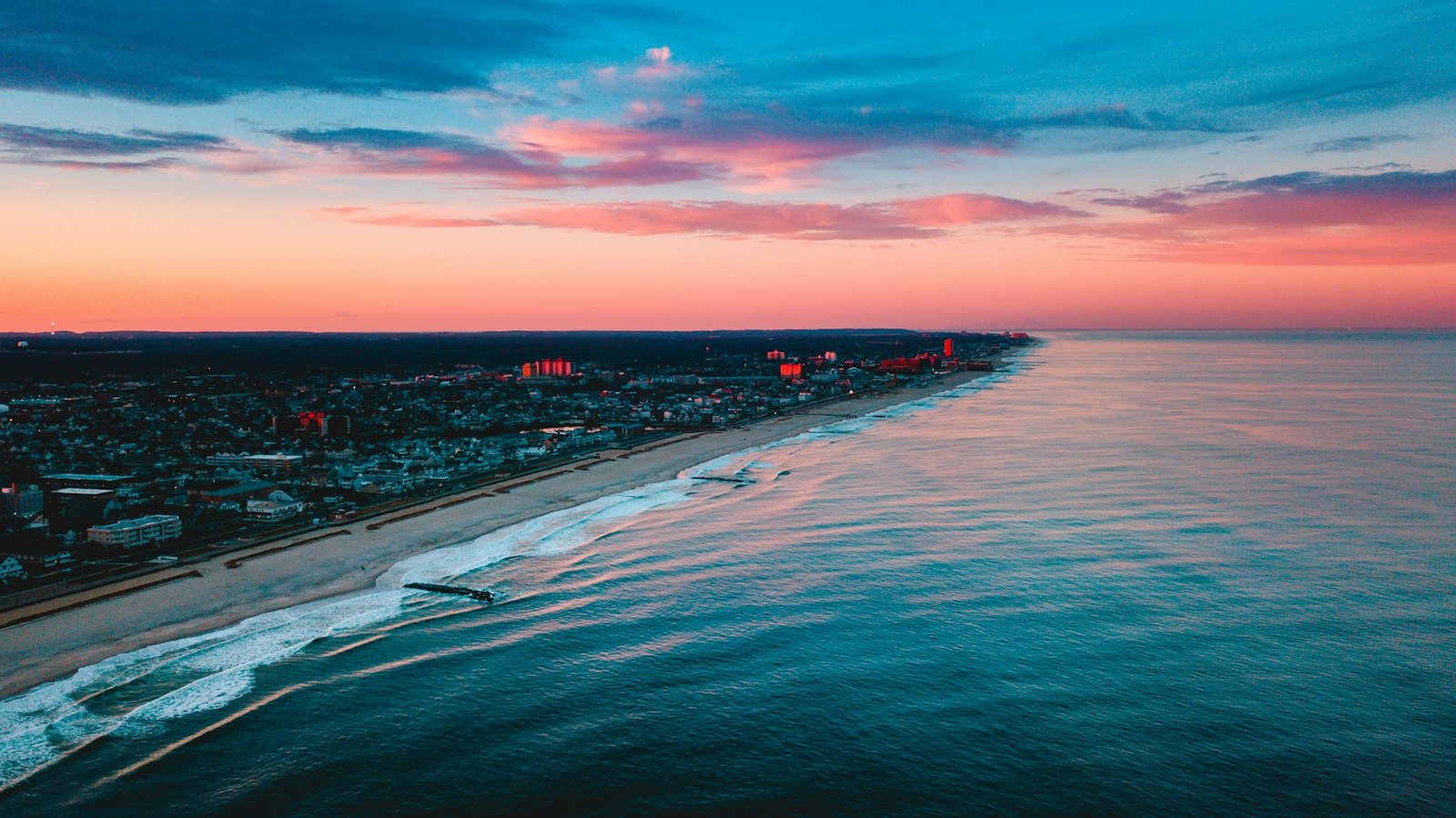 Aerial photography of buildings near ocean during golden hour