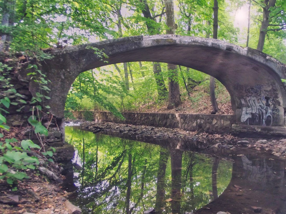 A bridge over a river with graffiti on it
