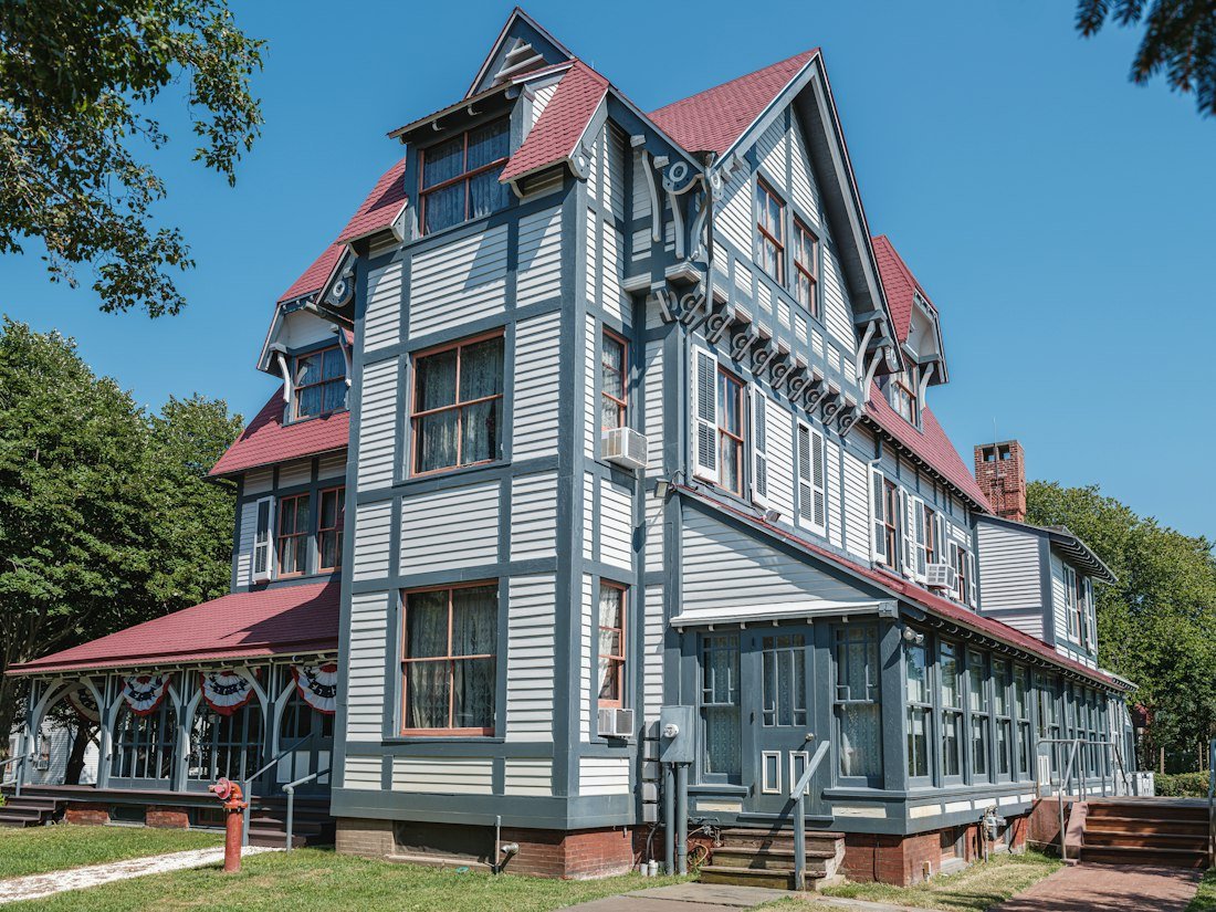 A large gray house with a red roof