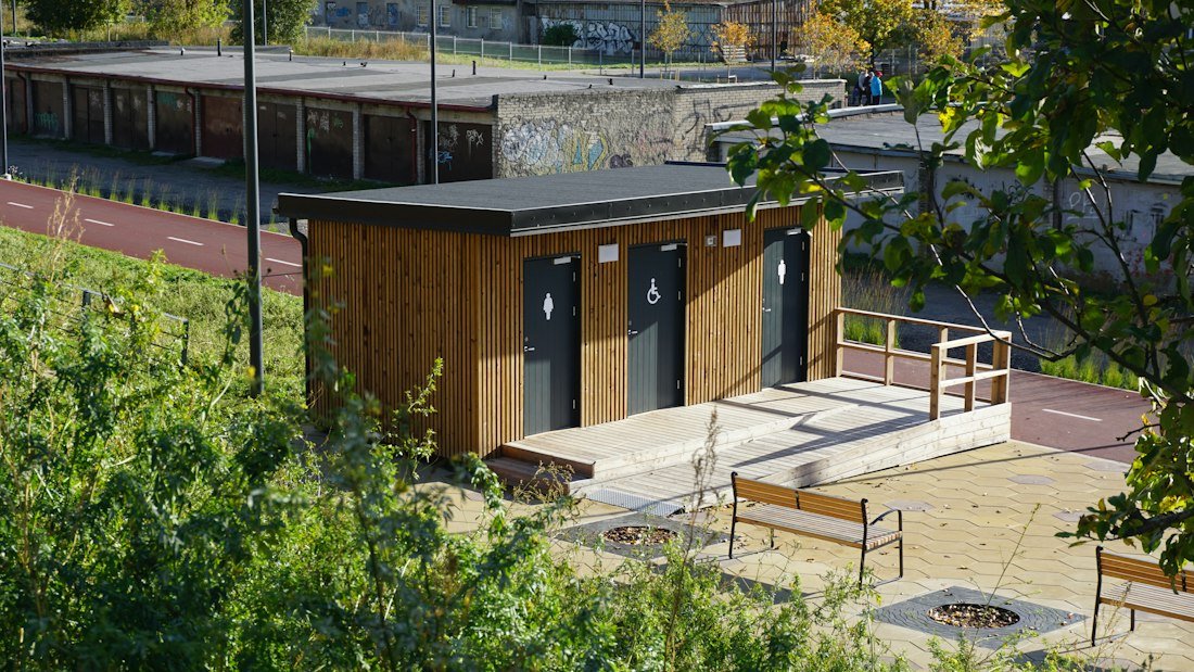 Wooden public restroom building with three doors