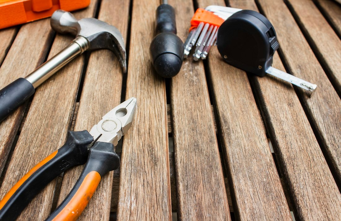 Assorted carpentry tools on a brown surface