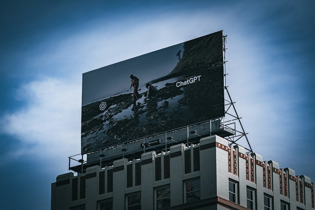 Billboard on top of a building against blue sky