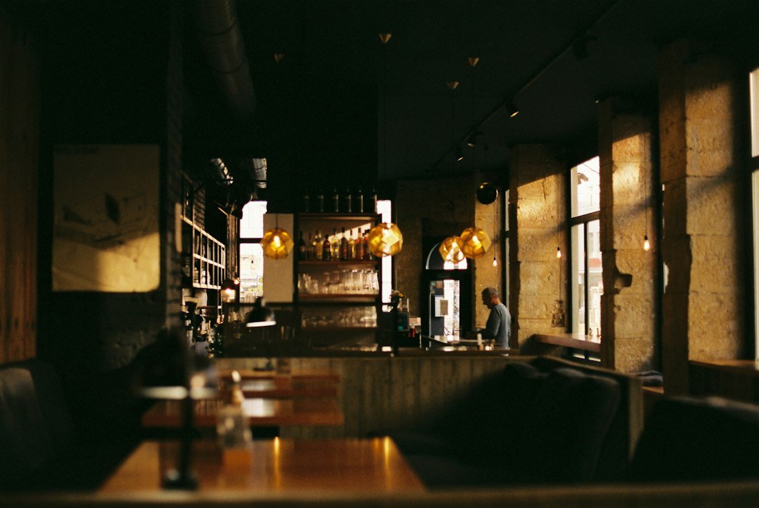 A dimly lit restaurant with tables and chairs