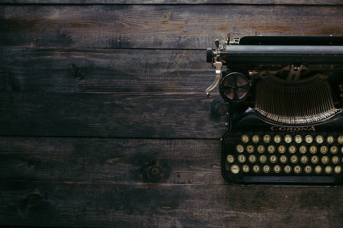 Black Corona typewriter on brown wood planks