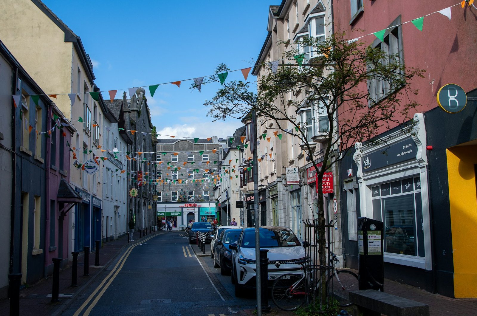 A narrow street lined with buildings and festive bunting