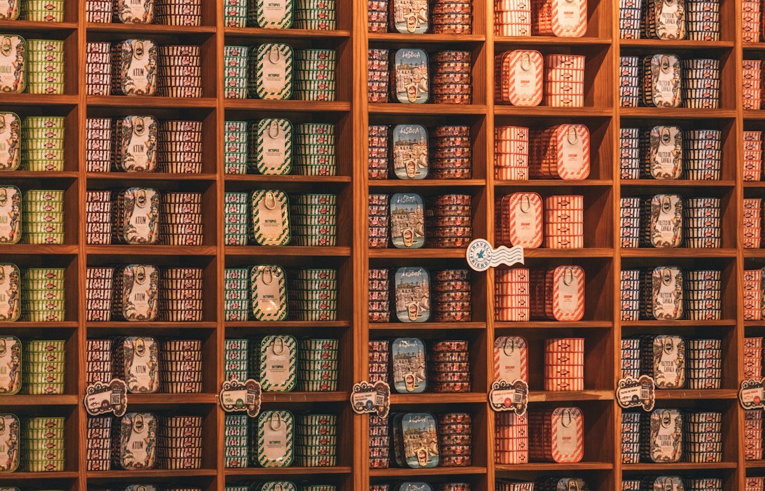 Shelves are stocked with many preserved food cans