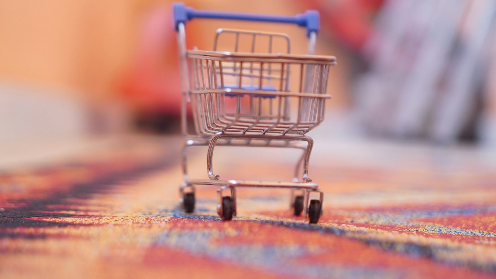 A miniature shopping cart sitting on top of a rug
