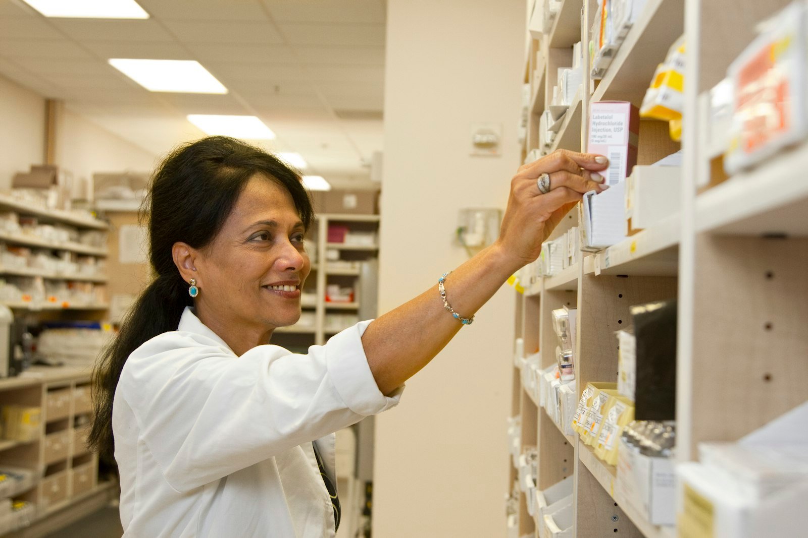 http://Pharmacist%20selecting%20a%20medication%20box%20from%20the%20dispensary%20shelf